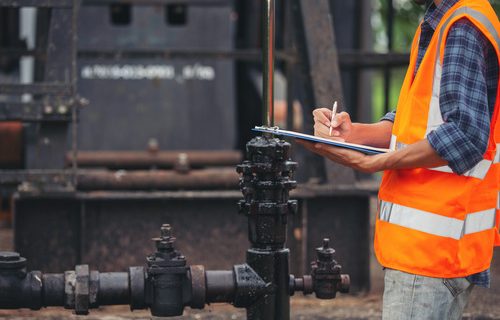 workers-standing-checking-beside-working-oil-pumps (1)